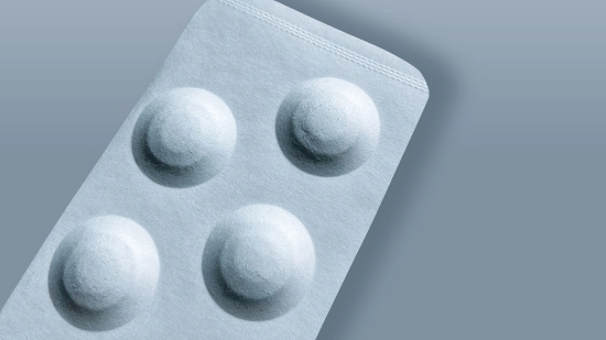 Primer plano de un blíster de papel con cavidades moldeadas para comprimidos