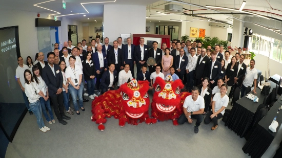 Uhlmann management and the team in Singapore pose for a group photo in an office with two dragons as mascots