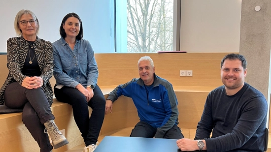 The Schick/Werz family sitting together in an office smiling at the camera.