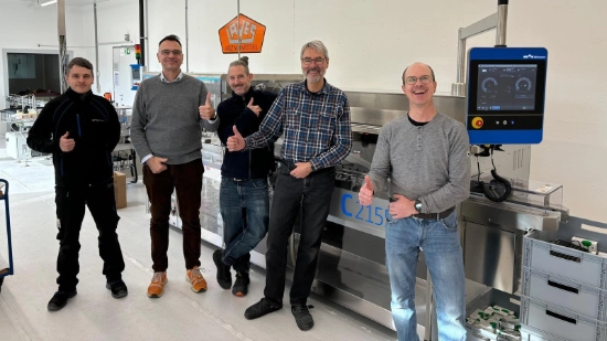 Five men from the Laves/Uhlmann project team in front of the cartoner with a “thumbs up” pose