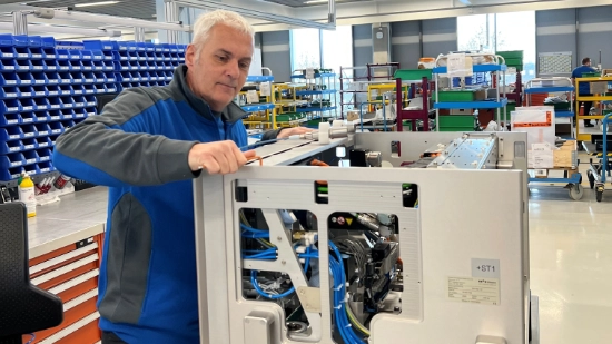 Michael Werz working on a machine assembly in a production hall.