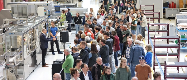 Blick in eine Industriehalle: Viele Menschen bewegen sich auf einem Parcours durch die Halle und betrachten Maschinen.