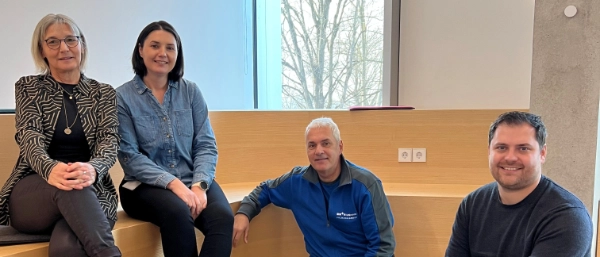 The Schick/Werz family sitting together in an office smiling at the camera.