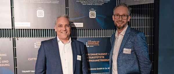 Dr. Mario Rometsch and Florian Wahler in front of a wall showcasing the Allianz Industry 4.0 Award 2025