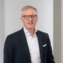 Portrait of CEO Prof. Dr.-Ing. Matthias Niemeyer standing indoors in front of a wall